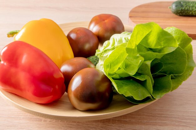 자연 식품 채식주의 개념의 주방 조리대에 있는 가정 농장에서 신선한 야채를 곁들인 큰 접시