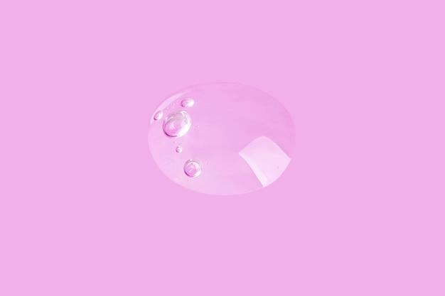 Large drop of clear gel on a pink background