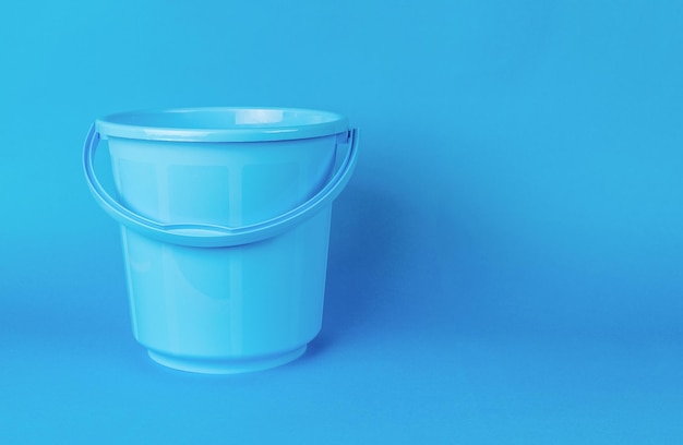 A large empty blue bucket on a blue background