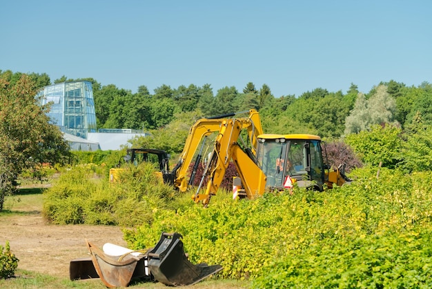 Large excavator in the field in front of the forest