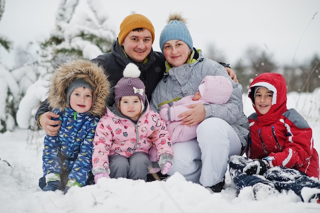 雪と降雪のある妖精の冬の日の4人の子供の肖像画の大家族。