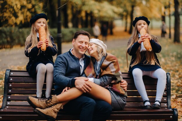 A large family is sitting on a bench in an autumn park Happy people in the autumn park