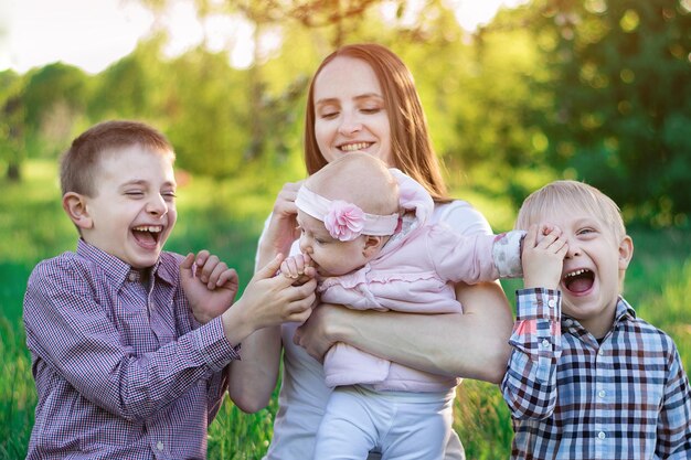 Large family walks in the Park Mother and three children Happy motherhood