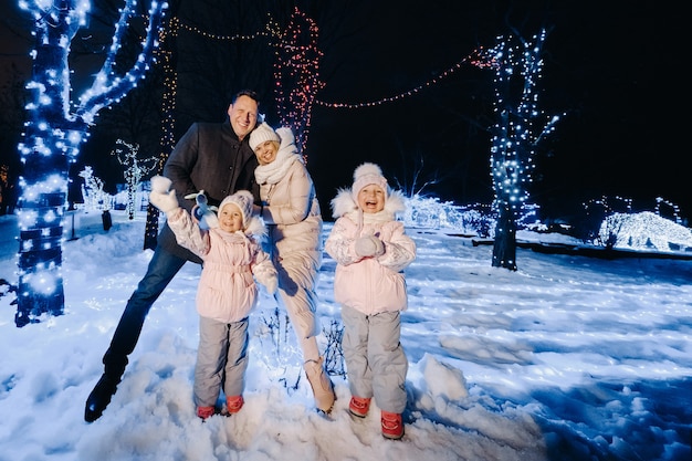 A large family with children in a Christmas city at night with night lights