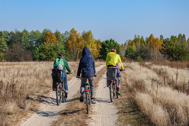 子供連れの大家族が森の中で自転車に乗っています