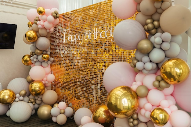 A large festive photo zone for a birthday decorated with gold sequins pink gray and gold balloons