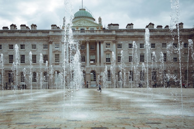 A large fountain in front of a building with the words'royal palace'on the top