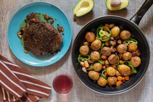 Large fried piece of ham meat in pan with vegetables spices lunch fried piece of meat and potatoes