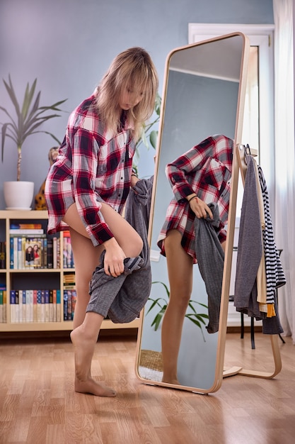 large full length standing mirror and female changes pants near it