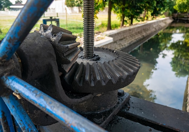 Photo a large gear mechanism used to create or close the flow of irrigation river water