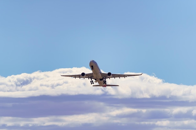 Large generic plane taking height towards the clouds after\
taking off from the ground