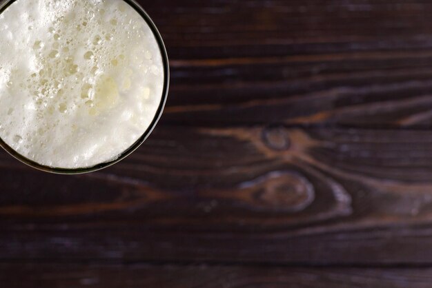 a large glass of cold light beer with foam on a dark background StPatrick s Day