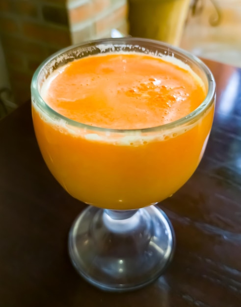 A large glass of orange juice mixed with carrot juice