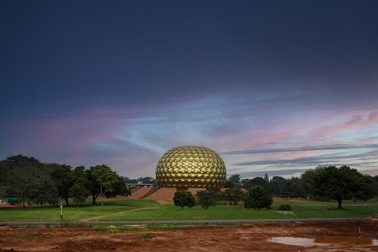 फोटो a large gold dome sits in a field with trees and a cloudy sky in the background