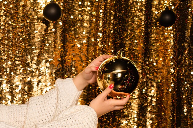  large Golden ball in hands on a shiny background