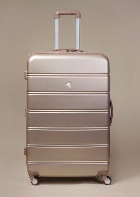 Large golden trolley suitcase isolated