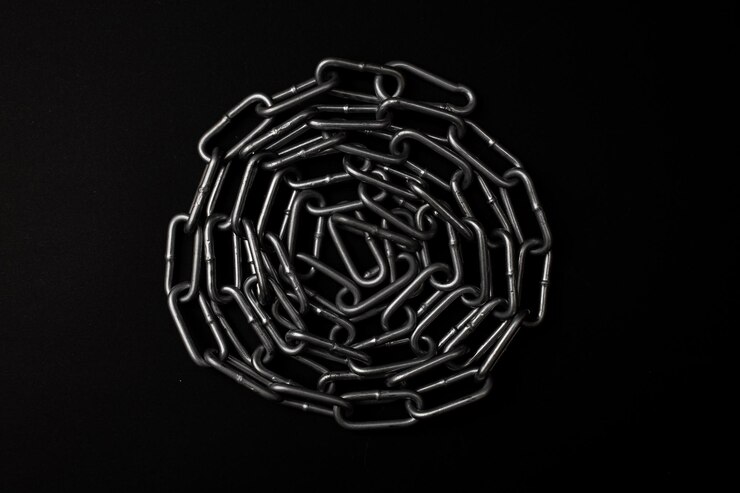 Large gray metal chain lies on a black background
