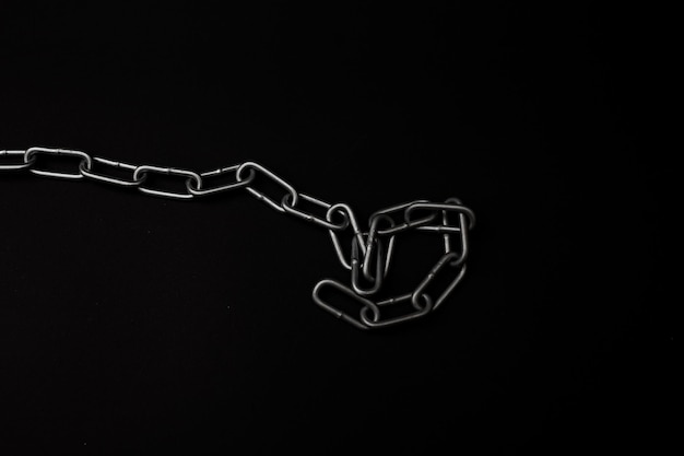 Large gray metal chain lies on a black background