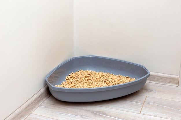 A large gray triangular plastic litter box for a cat