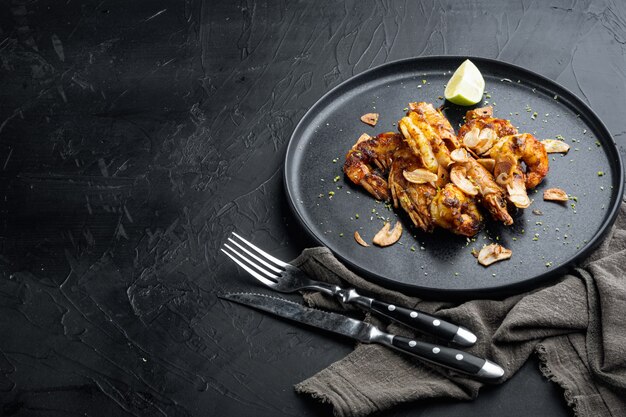 Large grilled BBQ shrimp with sweet Mango sauce and curry set, on plate, on black