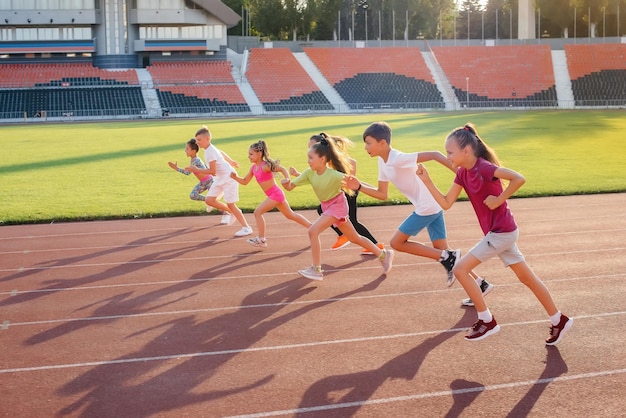 日没時には、子供、男の子、女の子の大規模なグループがスタジアムで走り、スポーツをします。健康的な生活スタイル。
