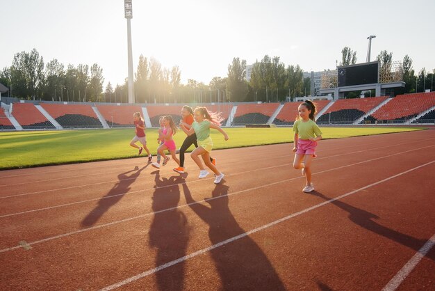 A large group of girls got ready at the start before running at\
the stadium during sunset a healthy lifestyle