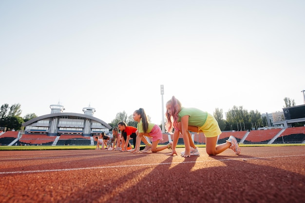 A large group of girls got ready at the start before running at the stadium during sunset A healthy lifestyle