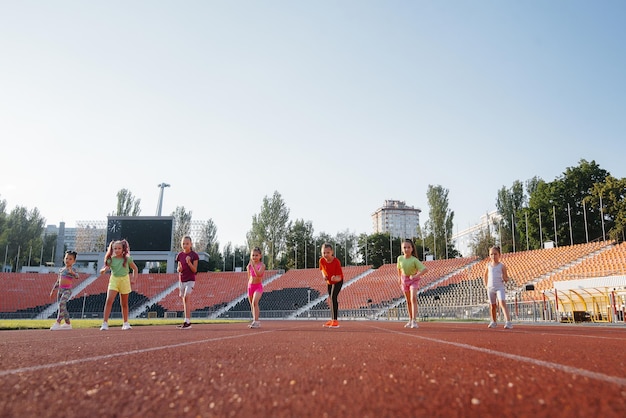 A large group of girls got ready at the start before running at the stadium during sunset A healthy lifestyle