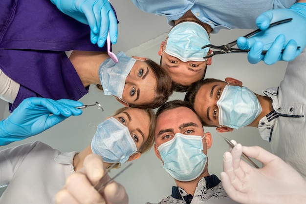 A large group of motivated doctors and nurses standing in a circle and joking with each other