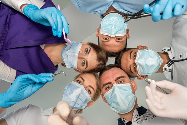 A large group of motivated doctors and nurses standing in a circle and joking with each other