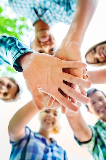 Large group of smiling friends staying together and looking at camera isolated on blue background