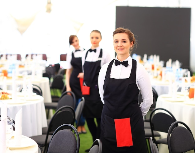 Large group of waiters and waitresses standing in row