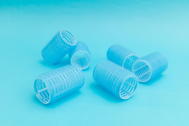 Large hair curlers on blue background monochrome