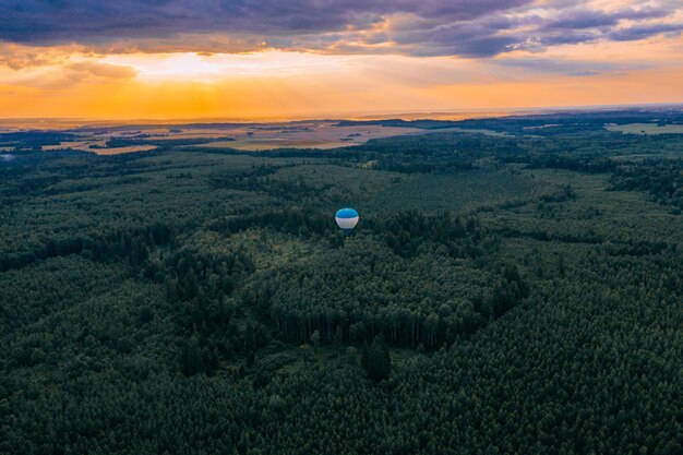 Photo on a large hot air balloon in the orange sunset incredible landscape