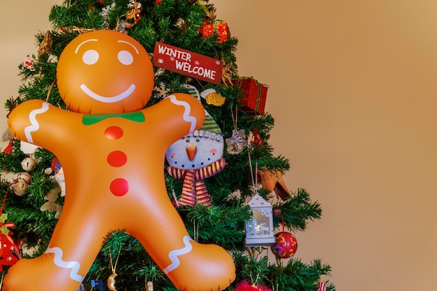 Large inflatable gingerbread man with copy space hanging on a Christmas tree.