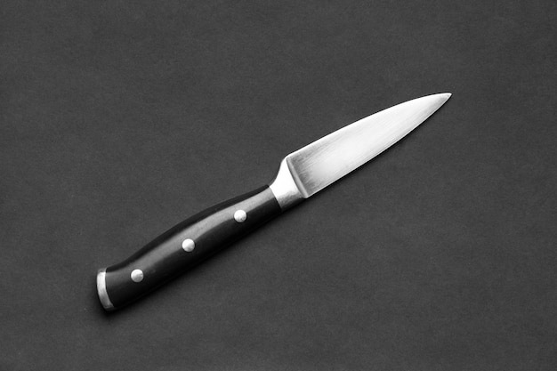 Large kitchen knife on a black background top view