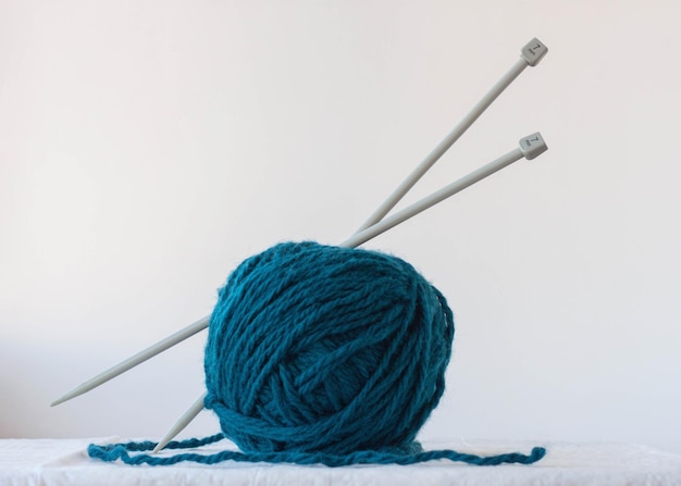 Premium Photo  Large knitting needles are stuck in a large ball of blue  yarn.