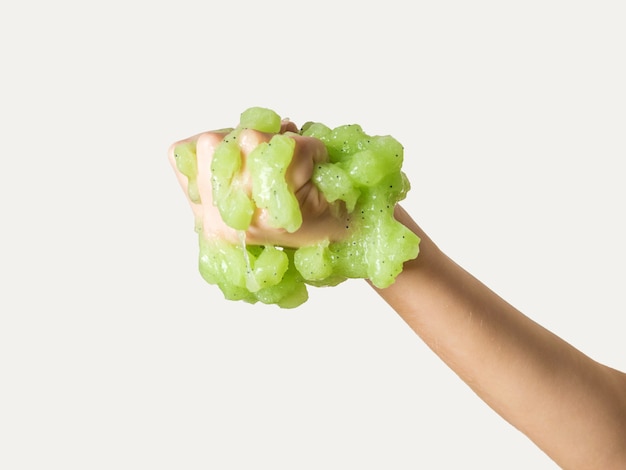 A large lump of green slime in his fist isolated on a white background. Popular children's game.