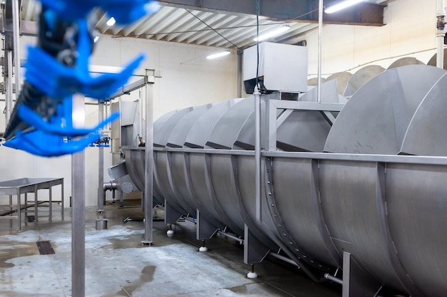 A large machine in a factory with a blue handle.