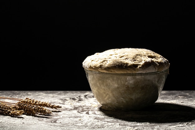 Grande ciotola di metallo con pasta al suo interno con farina