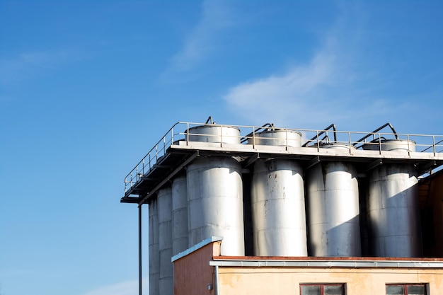 Large metal industrial containers on blue sky background