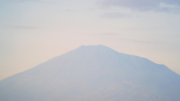 Photo a large mountain with a pink sky behind it