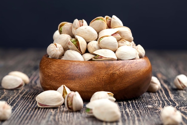 Large number of pistachios on a wooden table fried salted pistachio nuts