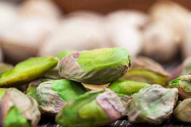 Large number of pistachios on a wooden table