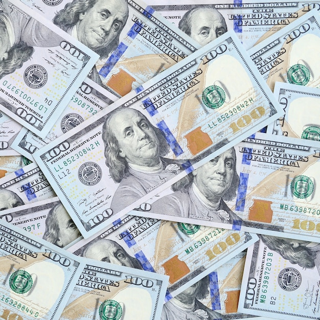 A large number of US dollar bills of a new design with a blue stripe in the middle. 