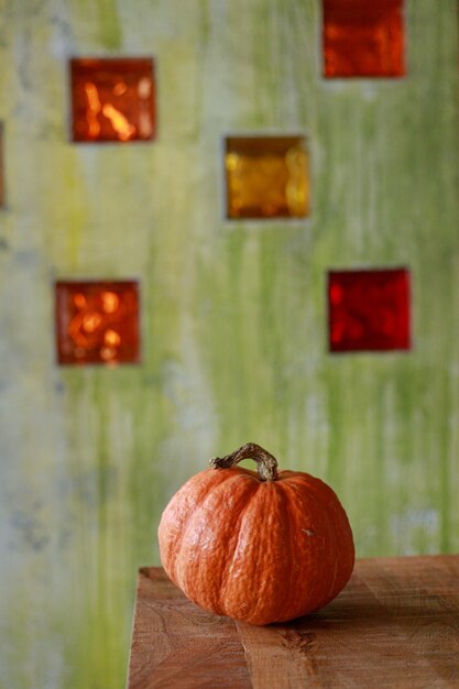 ハロウィーンのお祝いのための緑の背景の準備に大きなオレンジ色のカボチャ