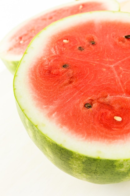 Large organic watermelon sliced on wood board.