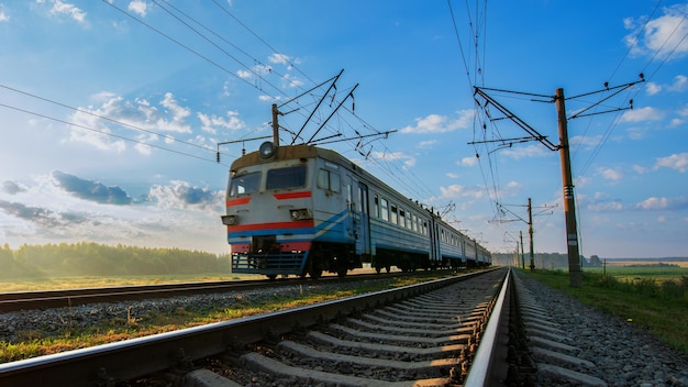 A large passenger train is heading in the direction of dawn. Place for text, concept, travel.