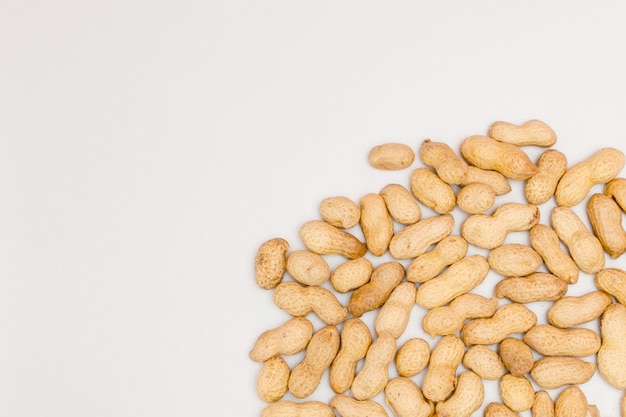 Photo large peeled peanuts close-up of beans in the shell. unpeeled peanuts in the shell.