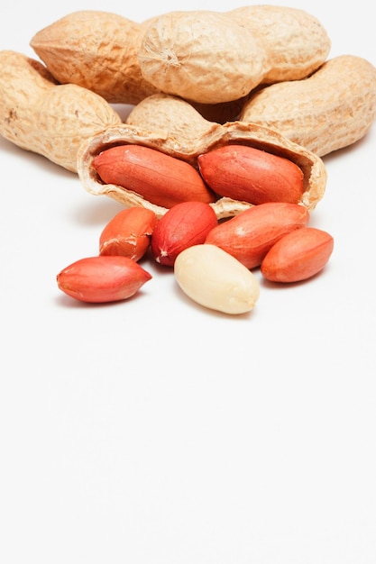 Large peeled peanuts closeup of beans in the shell Unpeeled peanuts in the shell Peanuts for background or texture Growing organic protein